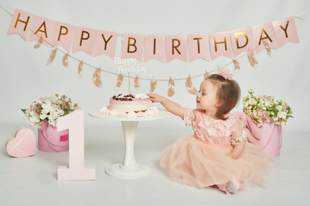 Smash cake party. Little birthday girl with first cake. One year baby celebration. Pink decor