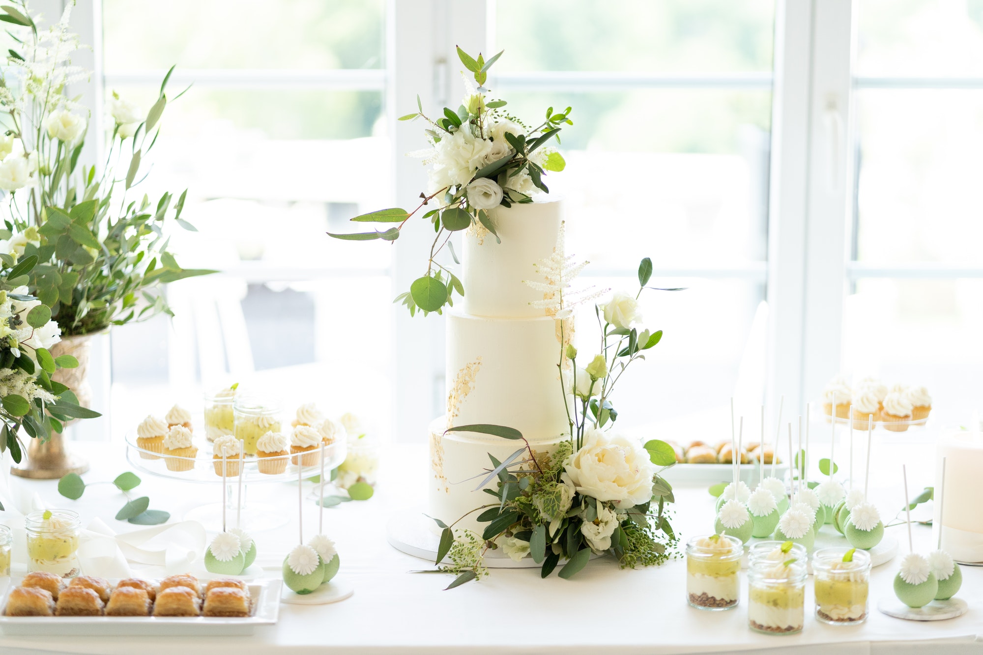 Wedding cake, cupcakes and sweets on a nicely decorated event table